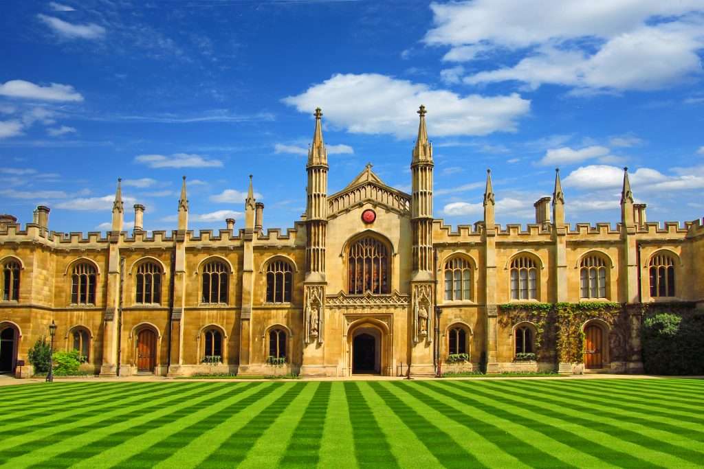 university in Cambridge with a beautiful lawn under a blue sky